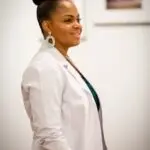 Portrait of a smiling female doctor in a white coat, exuding professionalism and confidence.